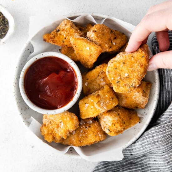 chicken nuggets in a bowl with ketchup.