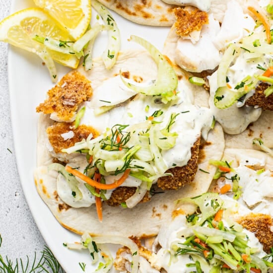 Fish tacos with slaw and lemon wedges.