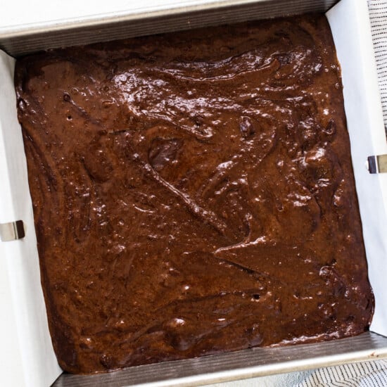 a pan of chocolate cake next to a bowl of chocolate chips.