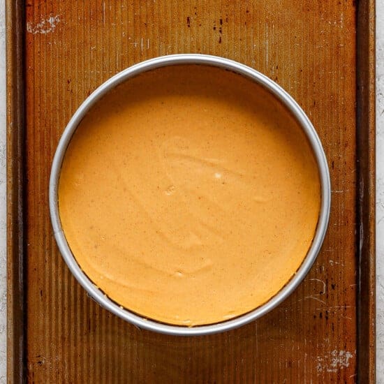 A bowl of pumpkin pie on a baking sheet.