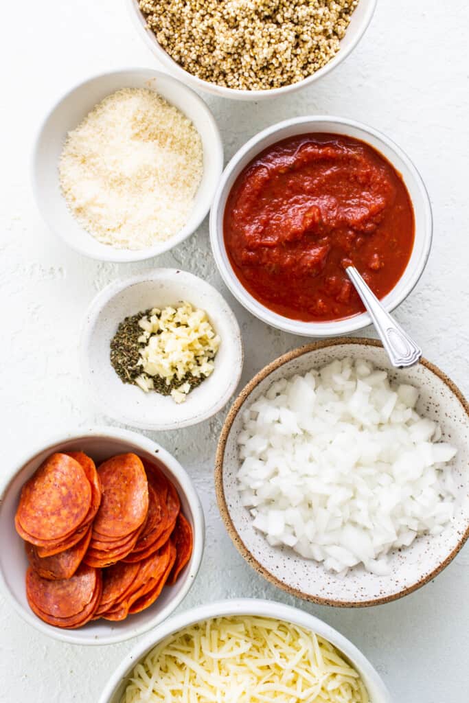 A bowl of ingredients for a pepperoni pizza.