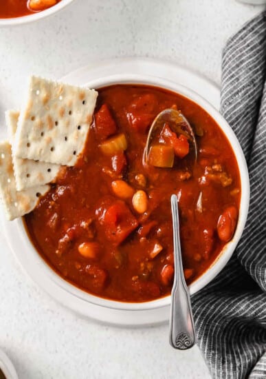 chili in bowl with crackers and a spoon.