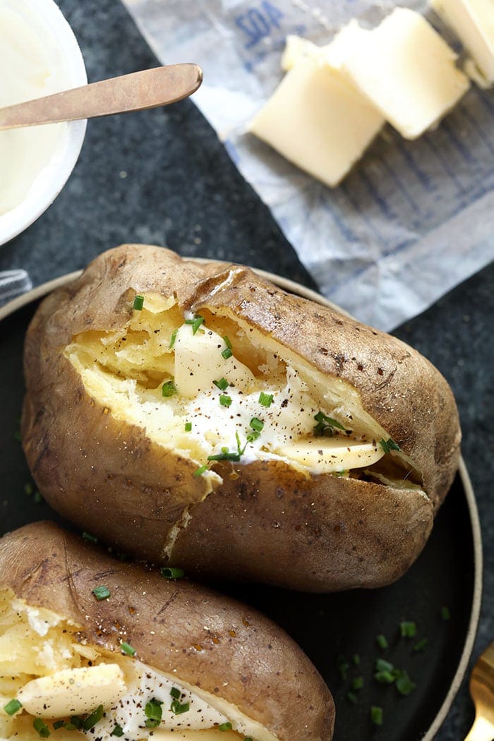 crock pot baked potatoes topped with chives and sour cream