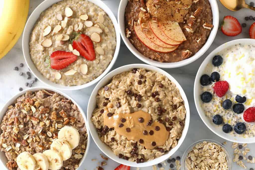 5 bowls of oatmeal and toppings on coutnertop.