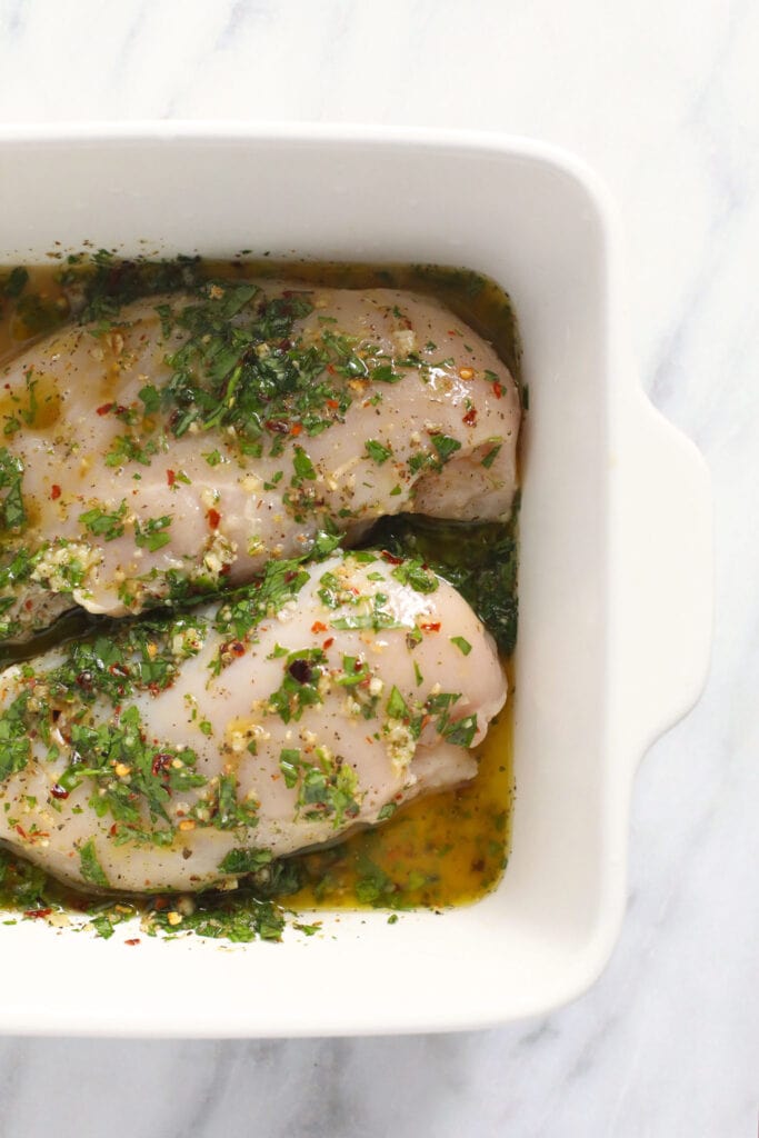 Marinating chicken in a pan. 