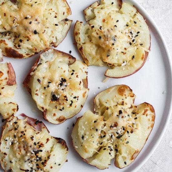 Smashed red potatoes on a plate.