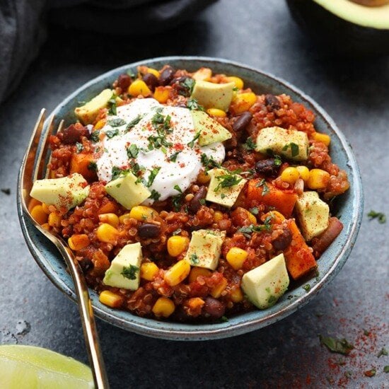 A Mexican bowl of chili topped with avocado and sour cream.